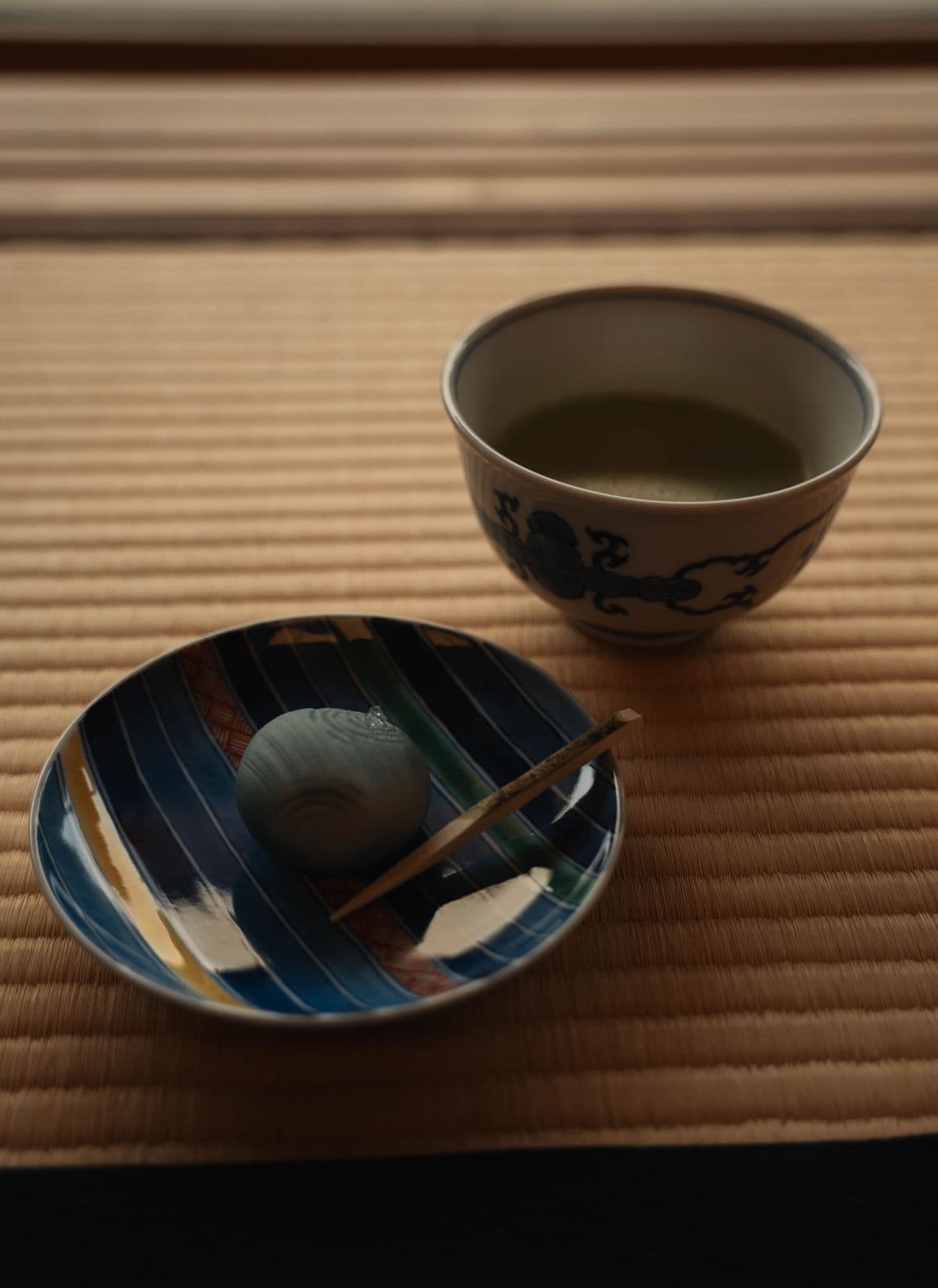 Green tea and a wagashi sweet served on a tatami mat
